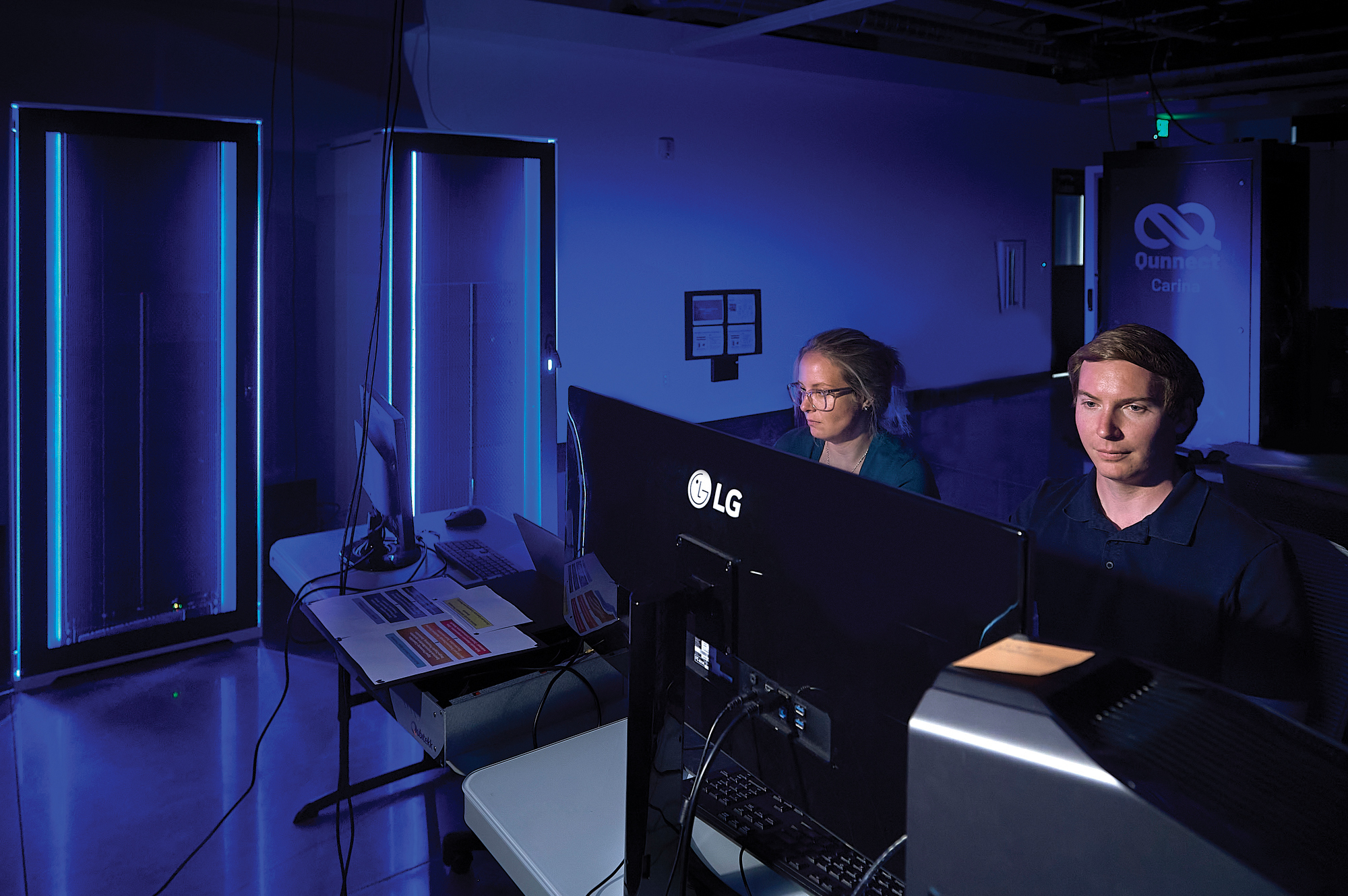 Catherine Hahola, assistant director of systems for Montana State University Information Technology, left, and Coltran Hophan-Nichols, director of systems and research computing, work with quantum computers in the QCORE facility. MSU photo by Kelly Gorham