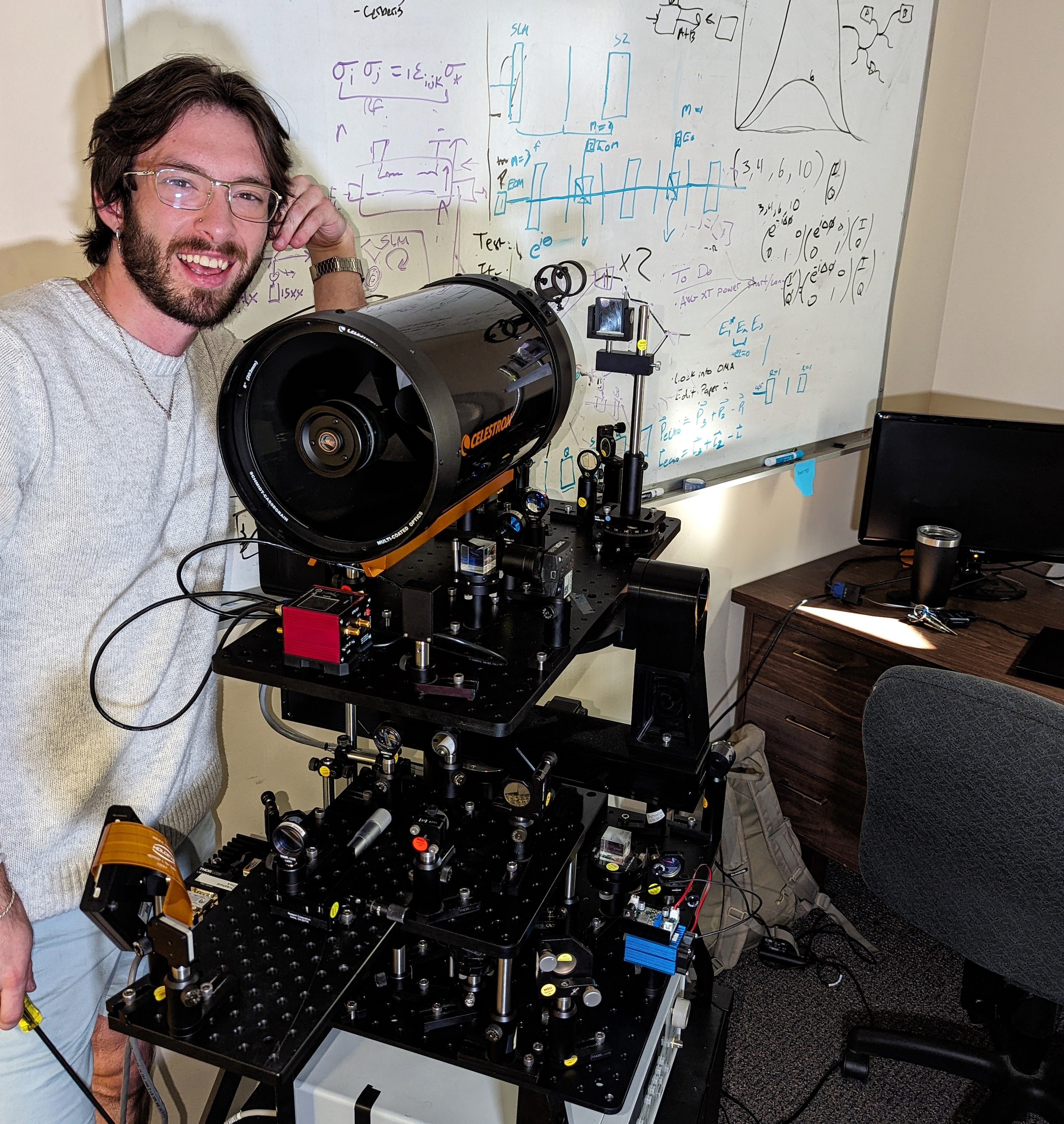 Caleb Rohn posing with free-space optical system